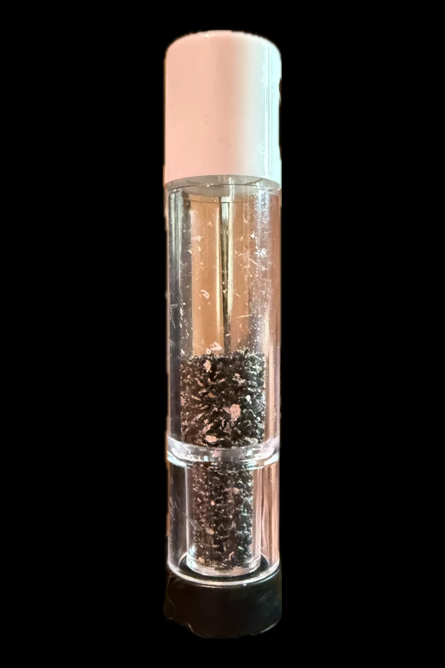 A pack of dragon fruit seeds: a clear vial with a white cap, the seeds resting at the bottom.